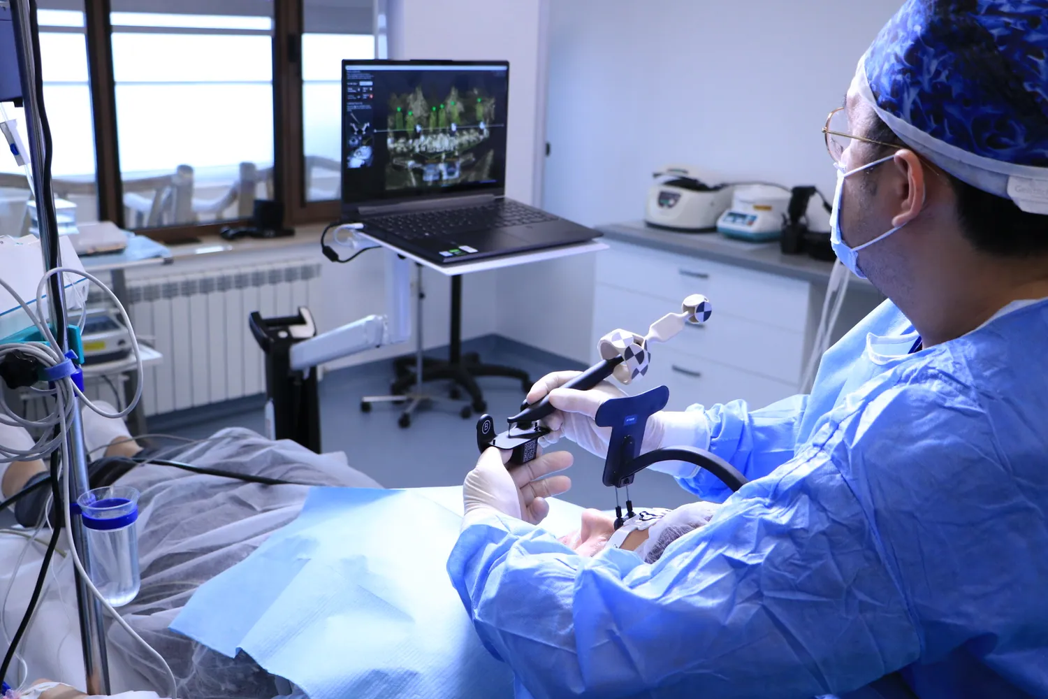 Dr. Olgun Chemal calibrează instrumentul Navident, cu planul implanturilor pe ecran